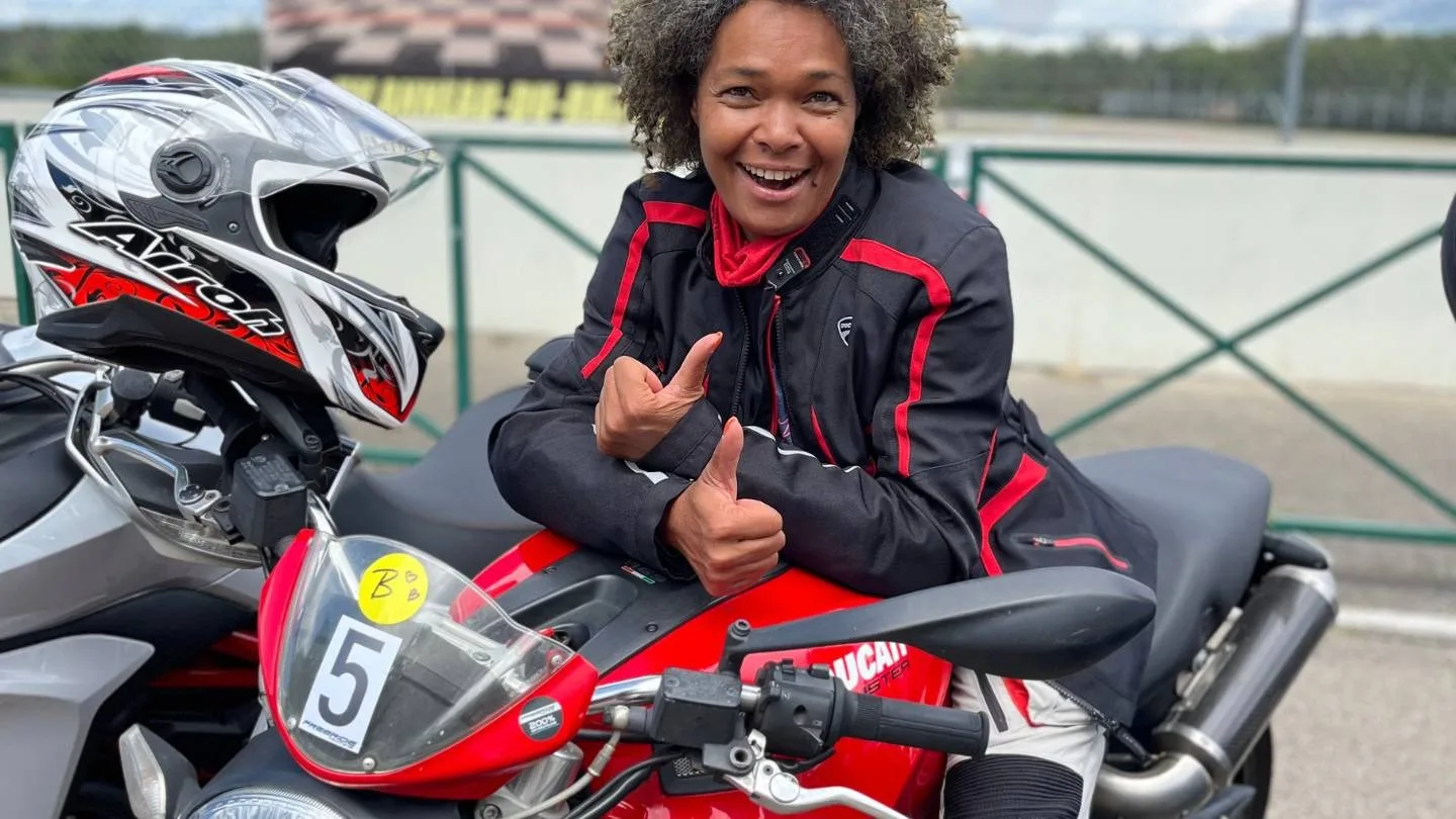Claudia Baumann lächelt auf einem Motorrad
